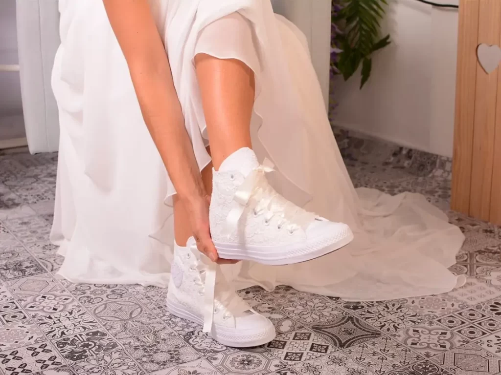 Bride and groom wearing custom wedding sneakers with Swarovski crystal details by Mad Alice.
